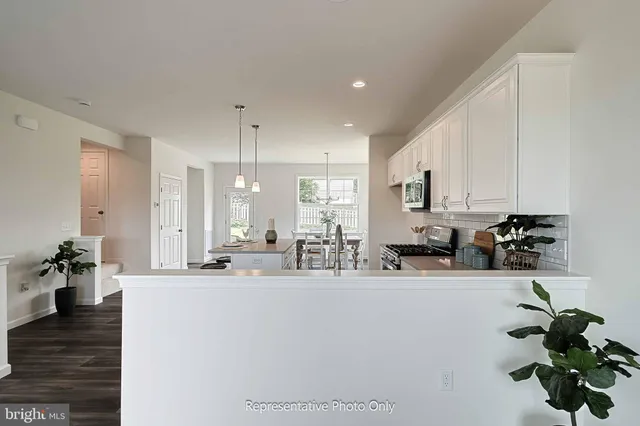 a kitchen with stainless steel appliances a white sink cabinets and wooden floor