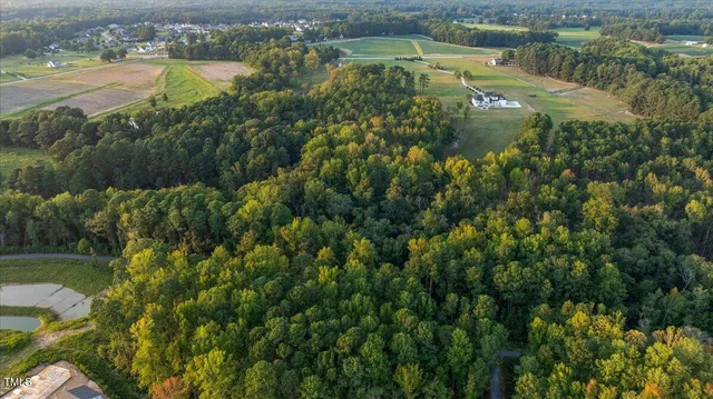 an aerial view of residential houses with outdoor space and lake view