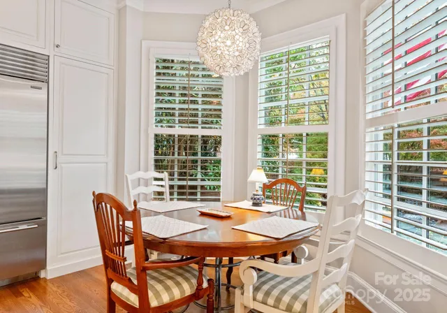 a dining room with furniture a chandelier and wooden floor