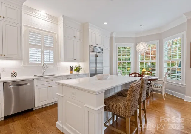 a kitchen with a table chairs sink and cabinets