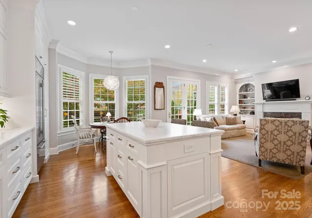 a large white kitchen with a large window and stainless steel appliances