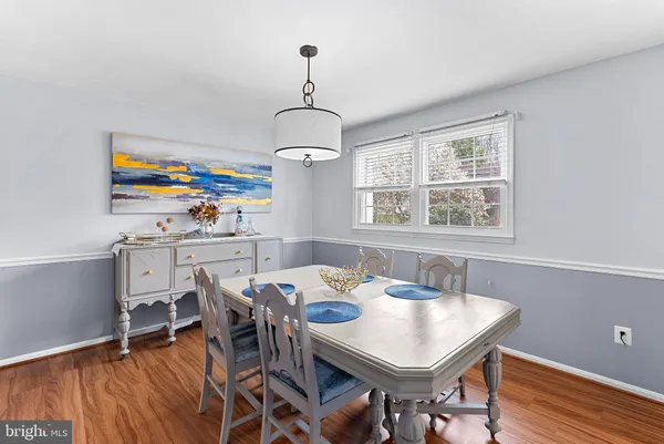 a view of a dining room with furniture a chandelier and wooden floor