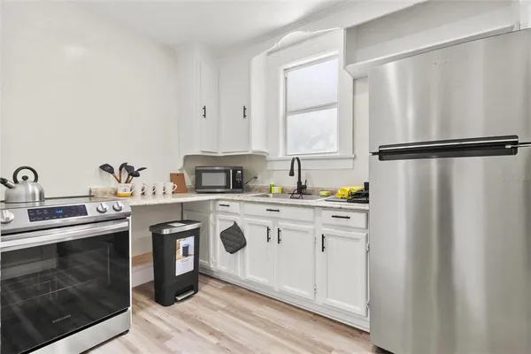 a kitchen with appliances a sink and cabinets
