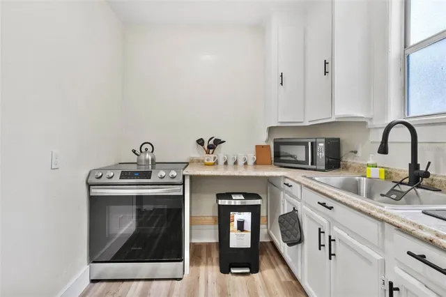 a kitchen with cabinets a sink and appliances