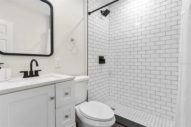 a bathroom with a toilet sink vanity and mirror