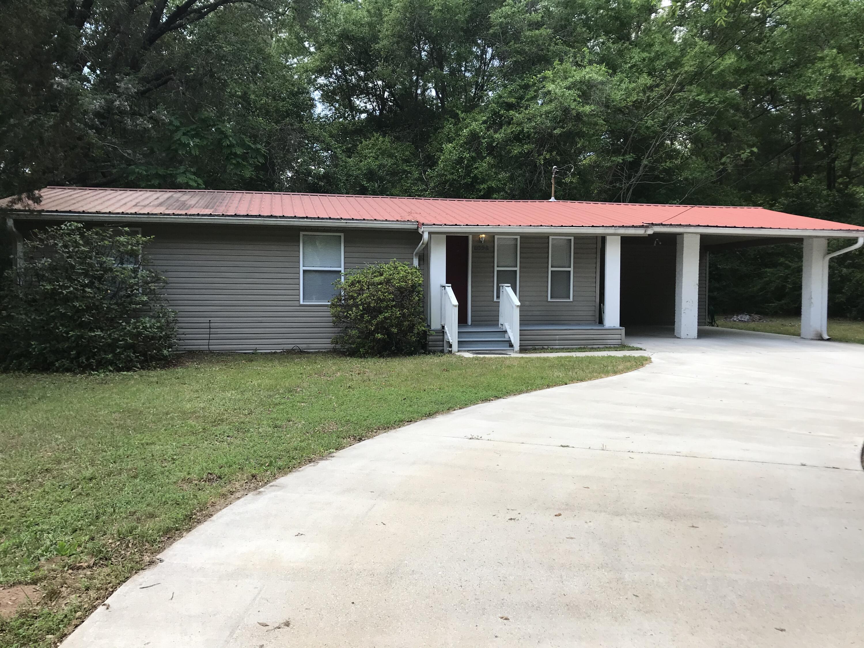 a view of a house with a yard and potted plants