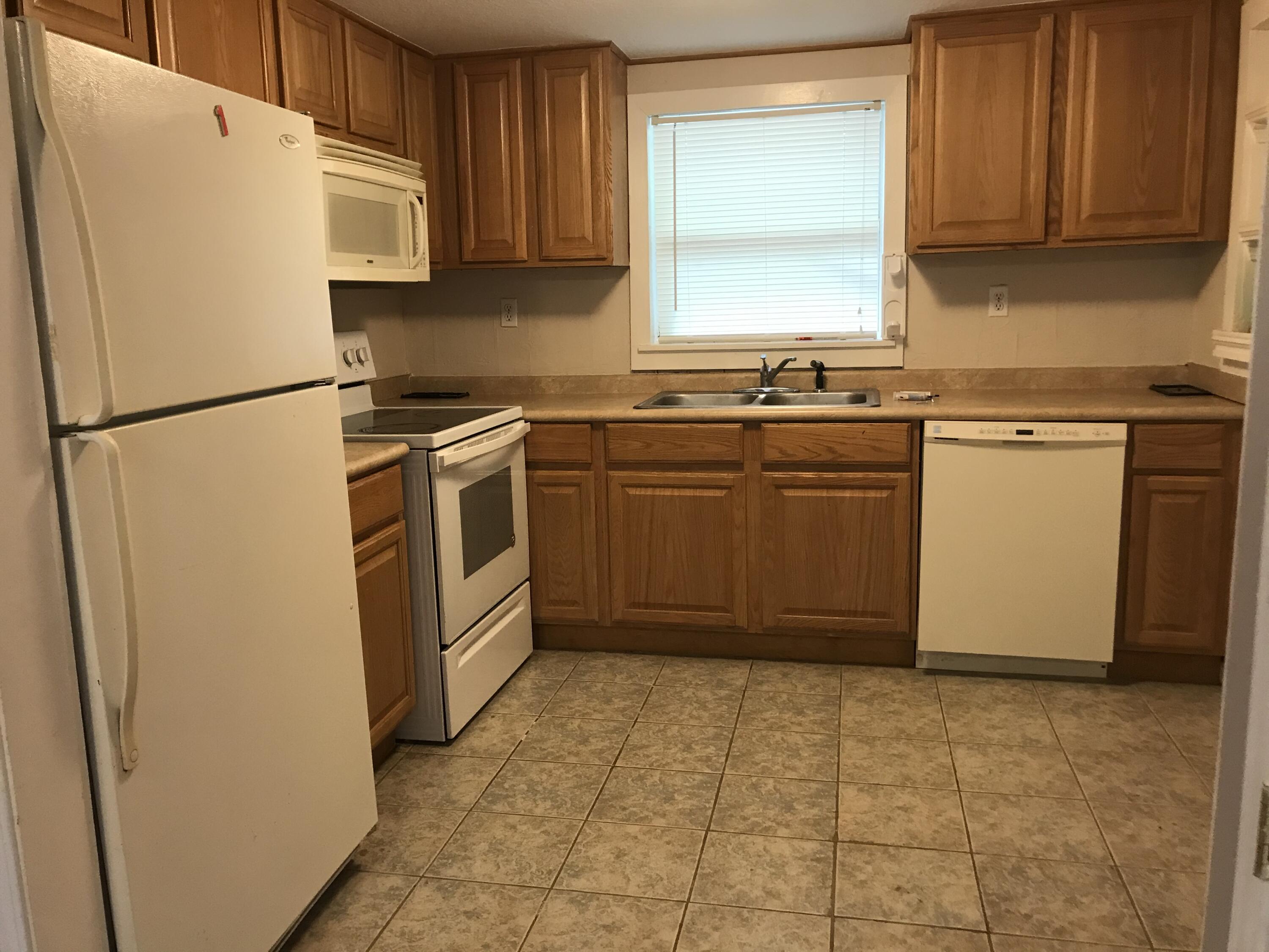 5098 Galiver Cutoff, Unit A Baker, FL 32531 - Photo 3 of 8 a kitchen with a refrigerator sink and cabinets
