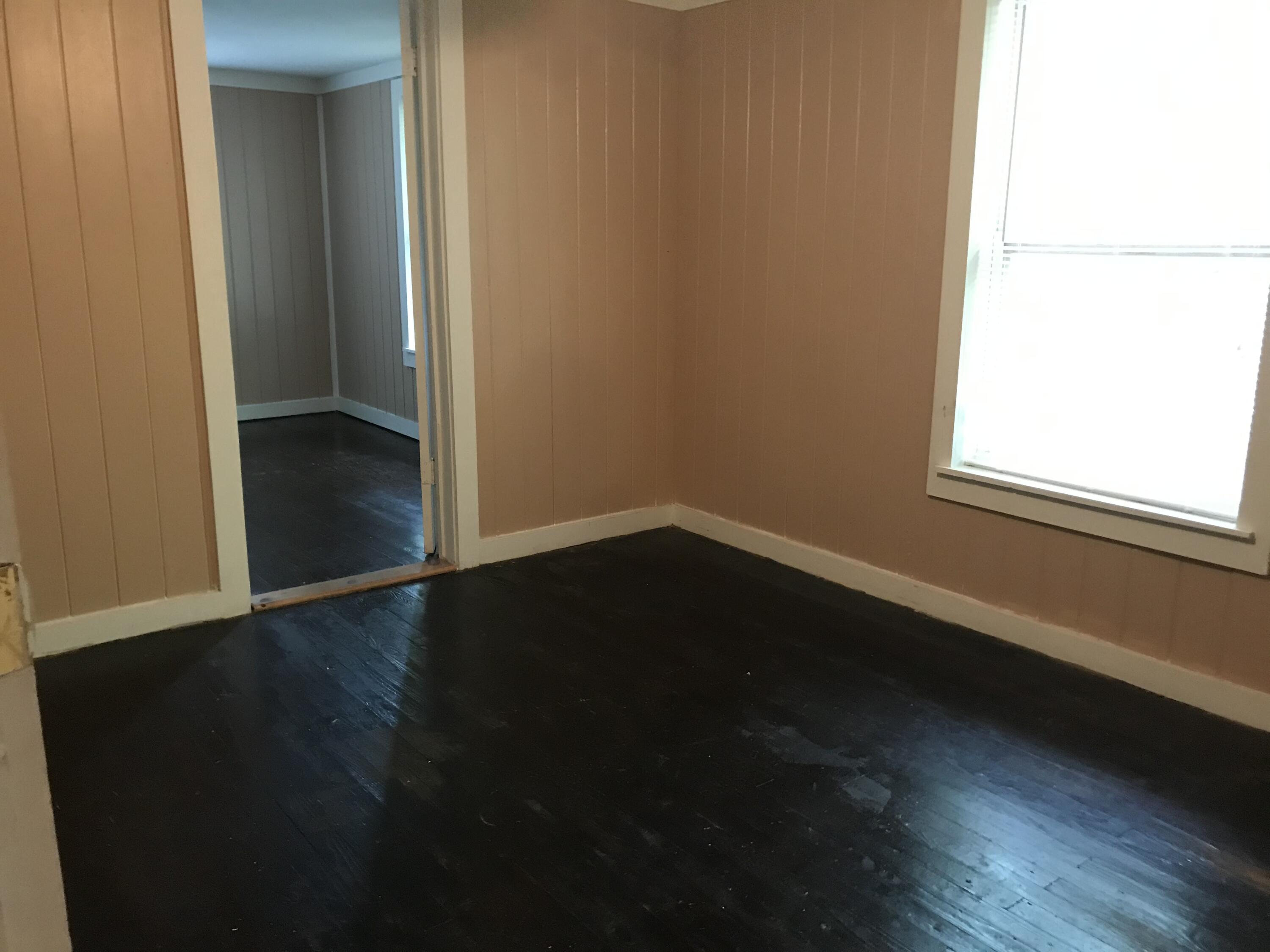 5098 Galiver Cutoff, Unit A Baker, FL 32531 - Photo 4 of 8 an empty room with wooden floor and windows