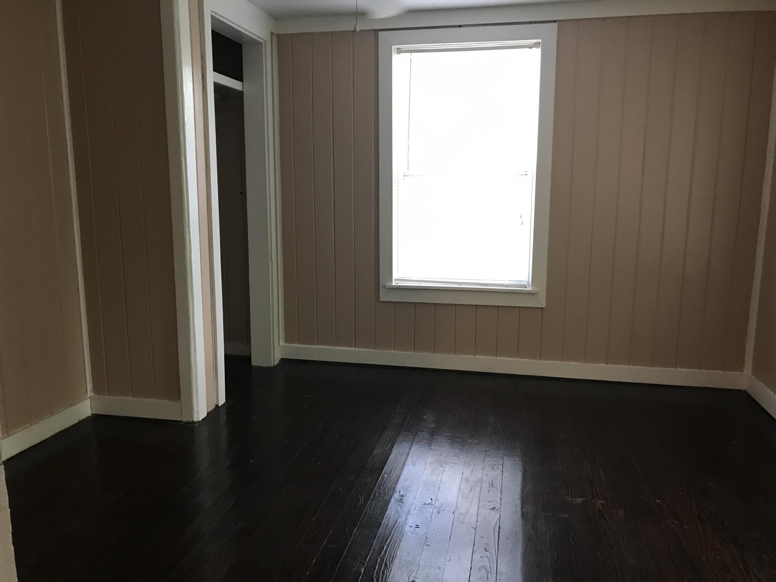 5098 Galiver Cutoff, Unit A Baker, FL 32531 - Photo 6 of 8 an empty room with wooden floor and windows