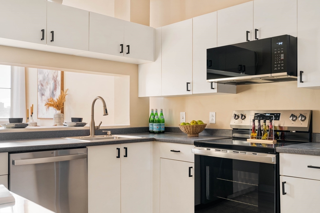 240 Heath Street, Unit PH16 Boston, MA 02130 - Photo 12 of 31 a kitchen with stainless steel appliances a sink a stove and a microwave