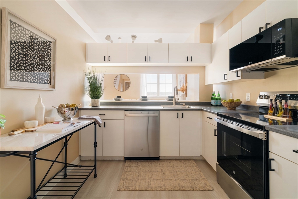 240 Heath Street, Unit PH16 Boston, MA 02130 - Photo 13 of 31 a kitchen with stainless steel appliances granite countertop a sink and cabinets
