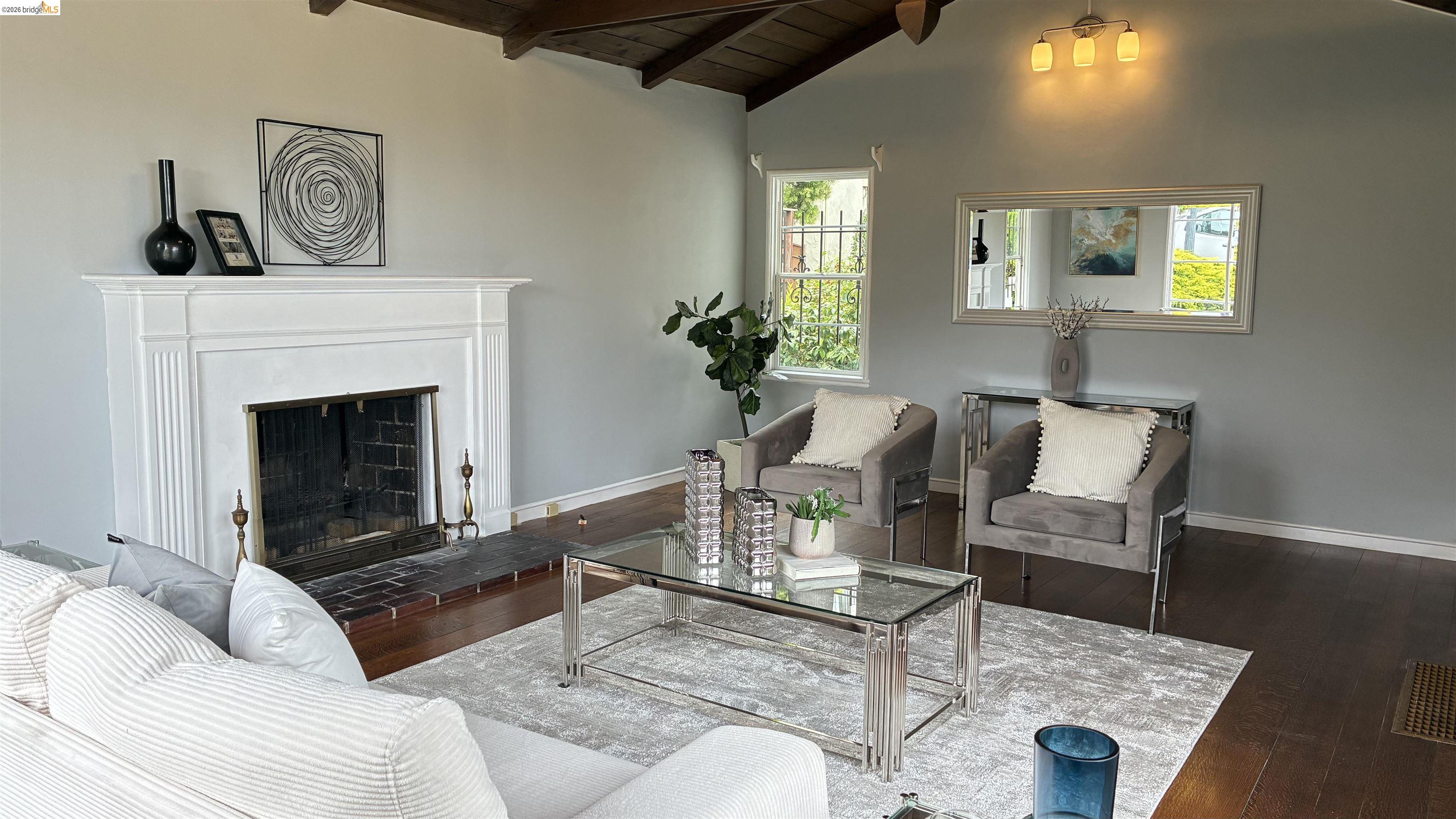 135 Alta Road Oakland, CA 94618 - Photo 5 of 42 Living area featuring a fireplace with raised hearth, dark wood-style flooring, and wood ceiling