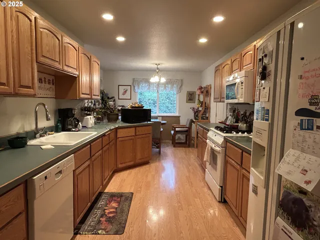 a kitchen with stainless steel appliances granite countertop lots of counter top space a sink a window and cabinets