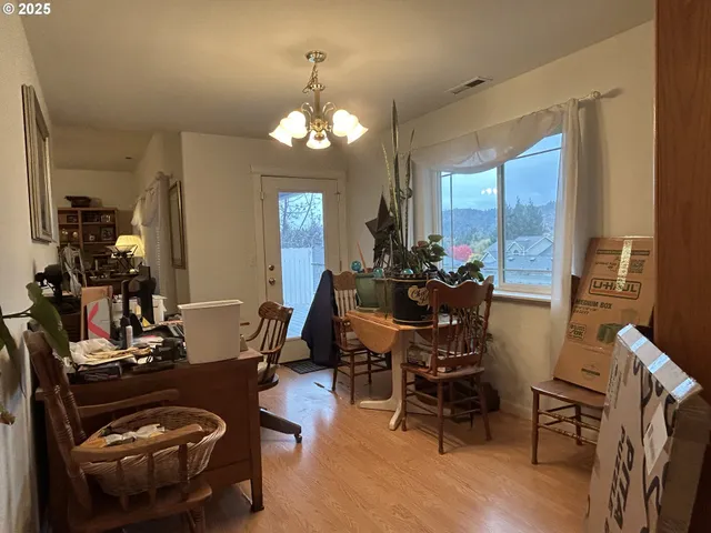a view of a dining room with furniture a chandelier and wooden floor