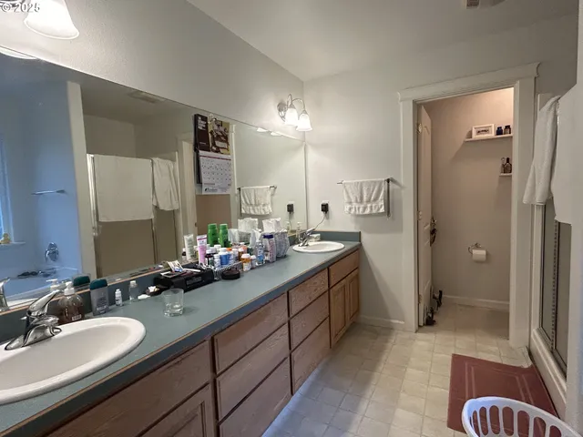 a bathroom with a sink double vanity granite tub shower and a mirror