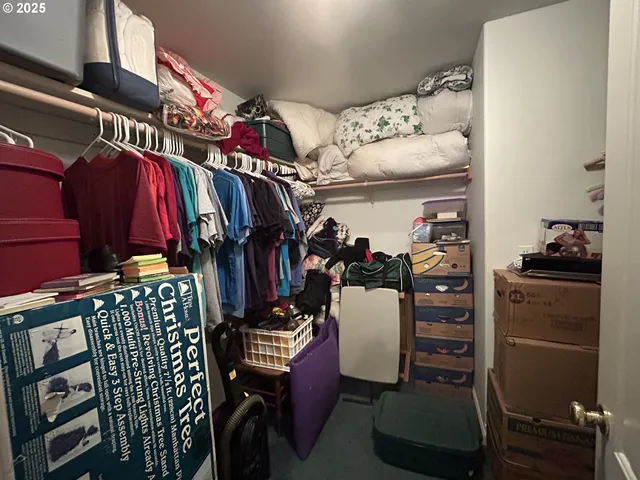 a view of walk in closet with clothes and shoes