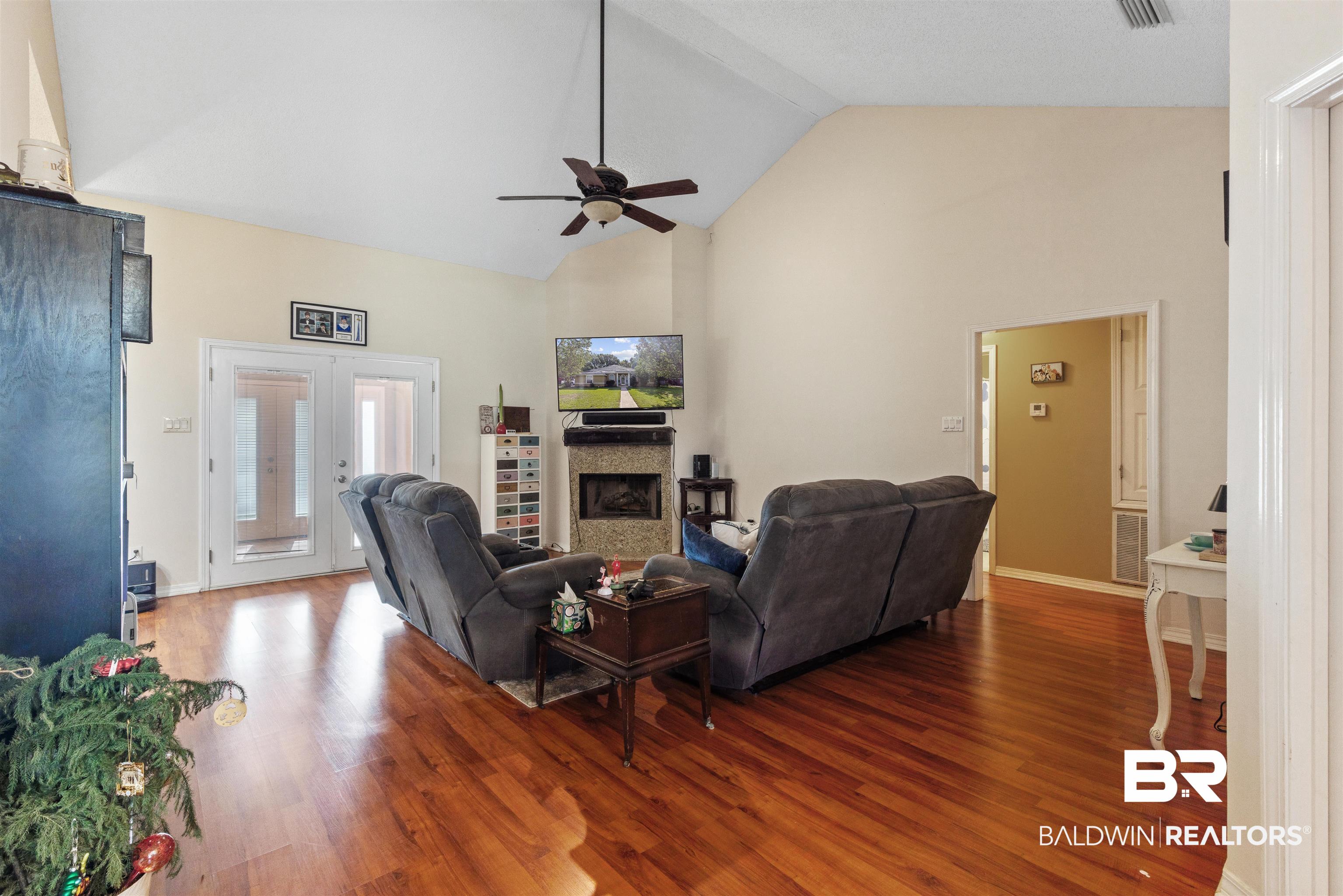 3075 Azalea Trace Drive Mobile, AL 36695 - Photo 11 of 33 Living area with high vaulted ceiling, a ceiling fan, wood finished floors, and a fireplace