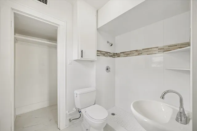 a bathroom with a toilet sink and shower
