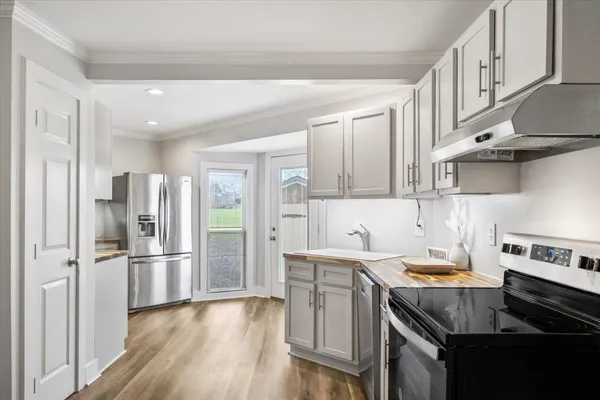 a kitchen with stainless steel appliances granite countertop a refrigerator and a stove top oven