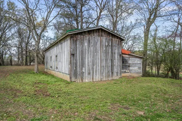 a view of a house with a yard and large tree