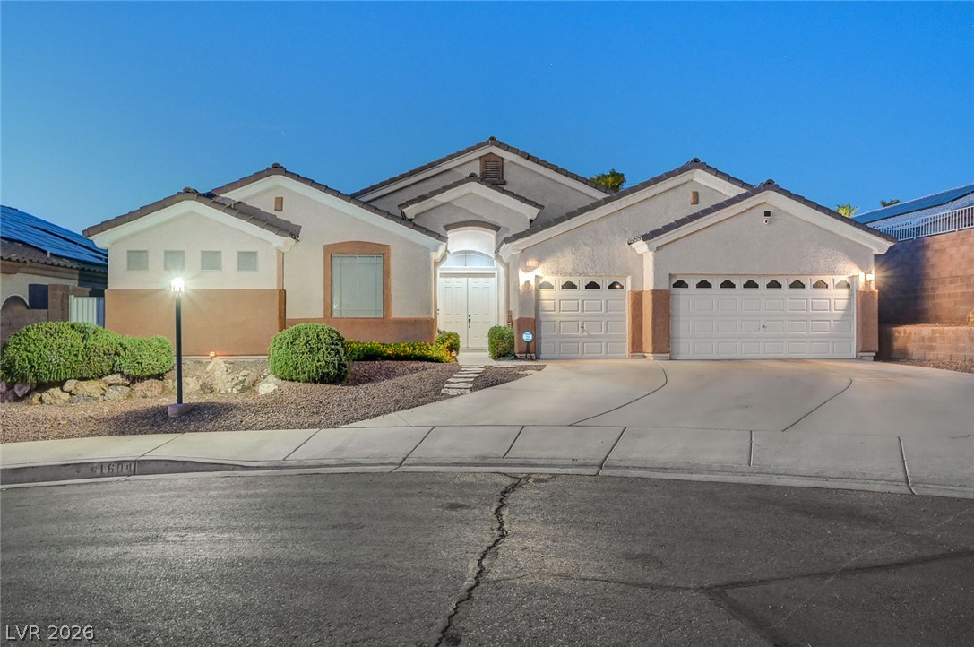 1604 Cattle Ranch Place Henderson, NV 89002 - Photo 2 of 99 A well-maintained stucco facade with a sweeping driveway welcomes visitors to this inviting home.