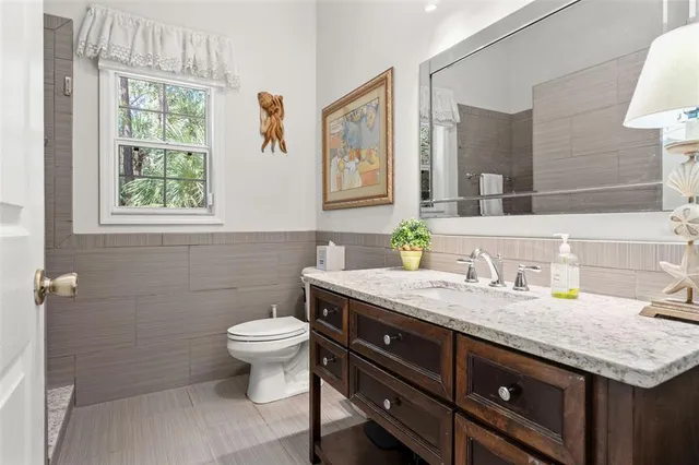 a bathroom with a granite countertop toilet sink and mirror