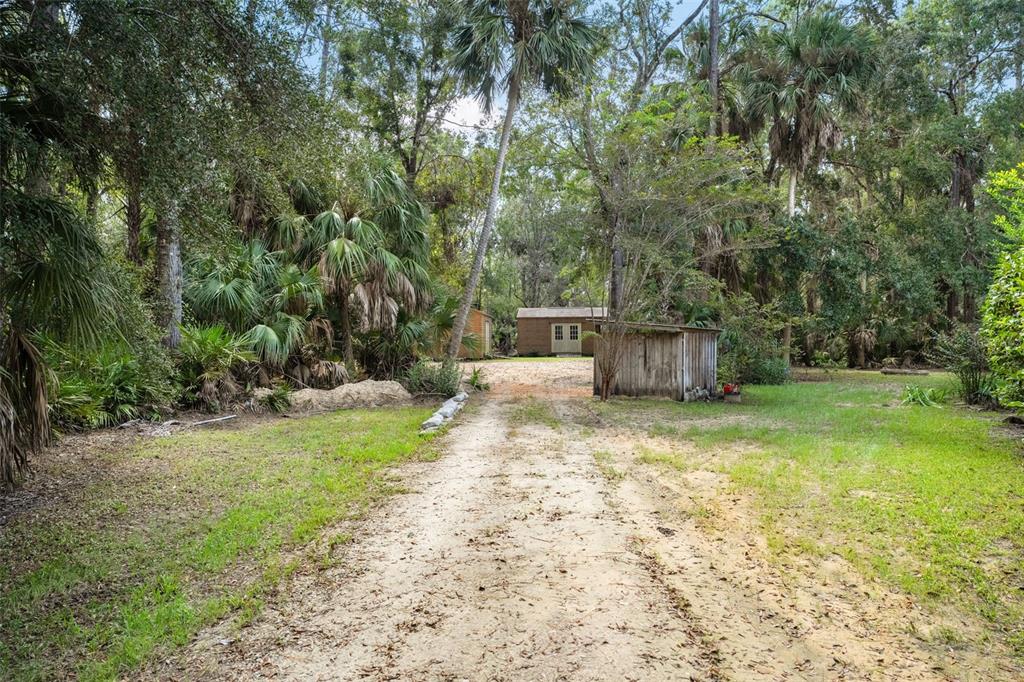 4270 Southeast 193rd Place Yankeetown, FL 34498 - Photo 32 of 42 a backyard of a house with trees and outdoor seating