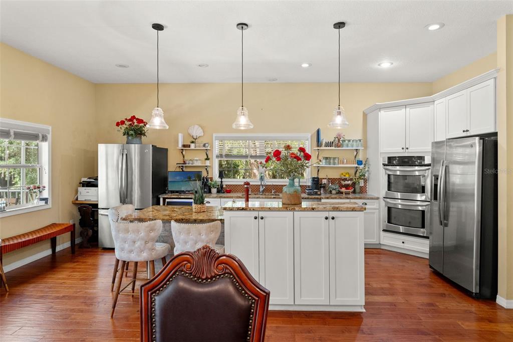 4270 Southeast 193rd Place Yankeetown, FL 34498 - Photo 7 of 42 a kitchen with stainless steel appliances kitchen island granite countertop a refrigerator a oven a sink and white cabinets with wooden floor