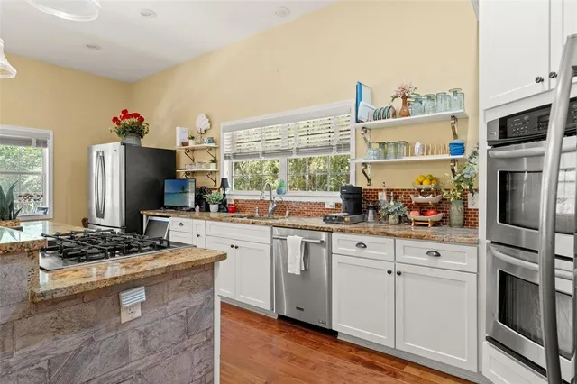a kitchen with stainless steel appliances granite countertop a stove and a refrigerator