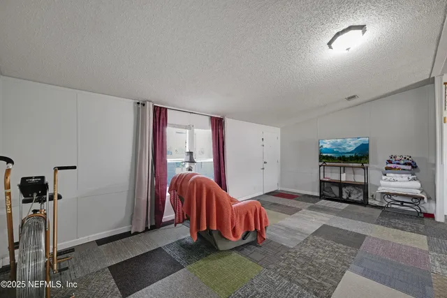 a living room with furniture gym equipment and a rug