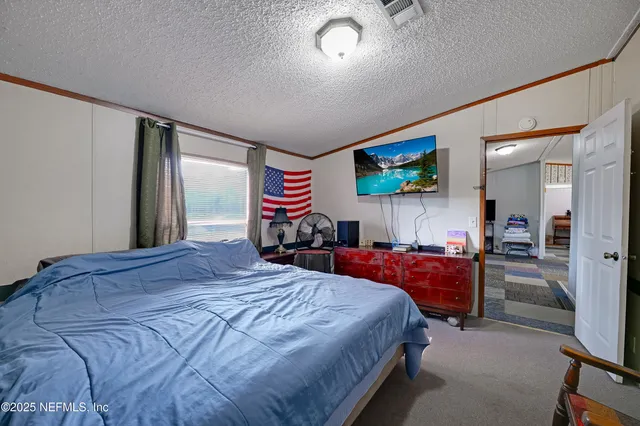 a bedroom with a bed and a flat screen tv