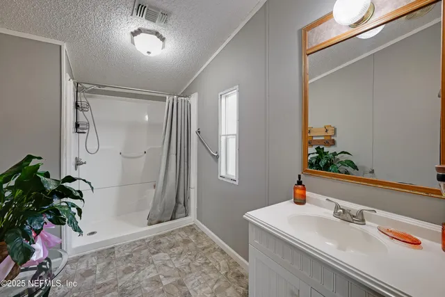 a bathroom with a shower sink vanity and mirror