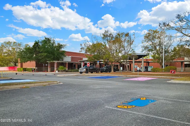 a front view of a building with lot of trees