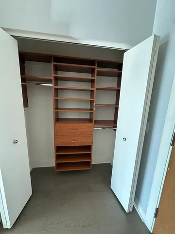 a view of walk in closet with empty racks