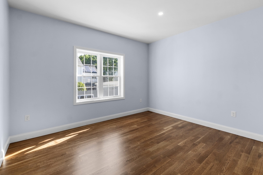 489 Spring Street Fall River, MA 02721 - Photo 16 of 42 a view of an empty room with wooden floor and a window