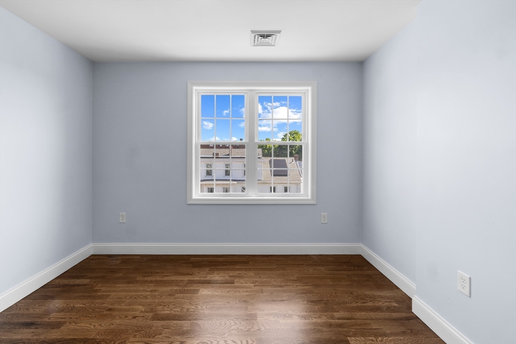 489 Spring Street Fall River, MA 02721 - Photo 34 of 42 a view of an empty room with wooden floor and a window
