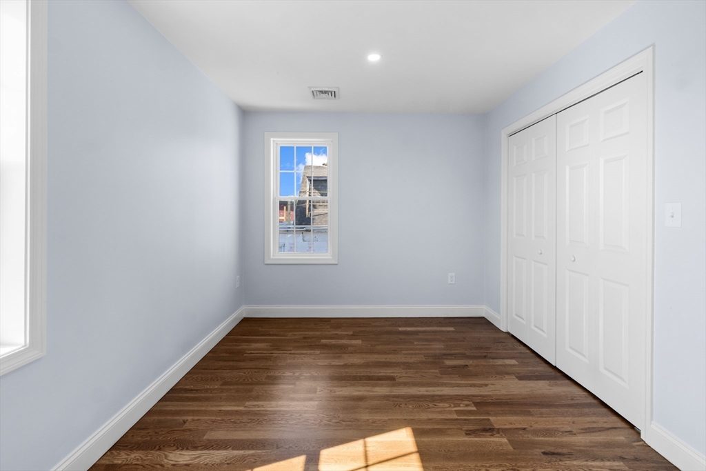 489 Spring Street Fall River, MA 02721 - Photo 35 of 42 an empty room with wooden floor and windows