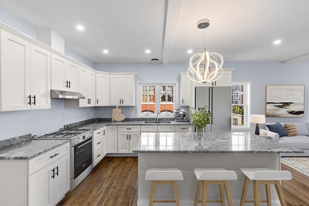 489 Spring Street Fall River, MA 02721 - Photo 5 of 42 a large kitchen with granite countertop lots of counter space white cabinets and stainless steel appliances