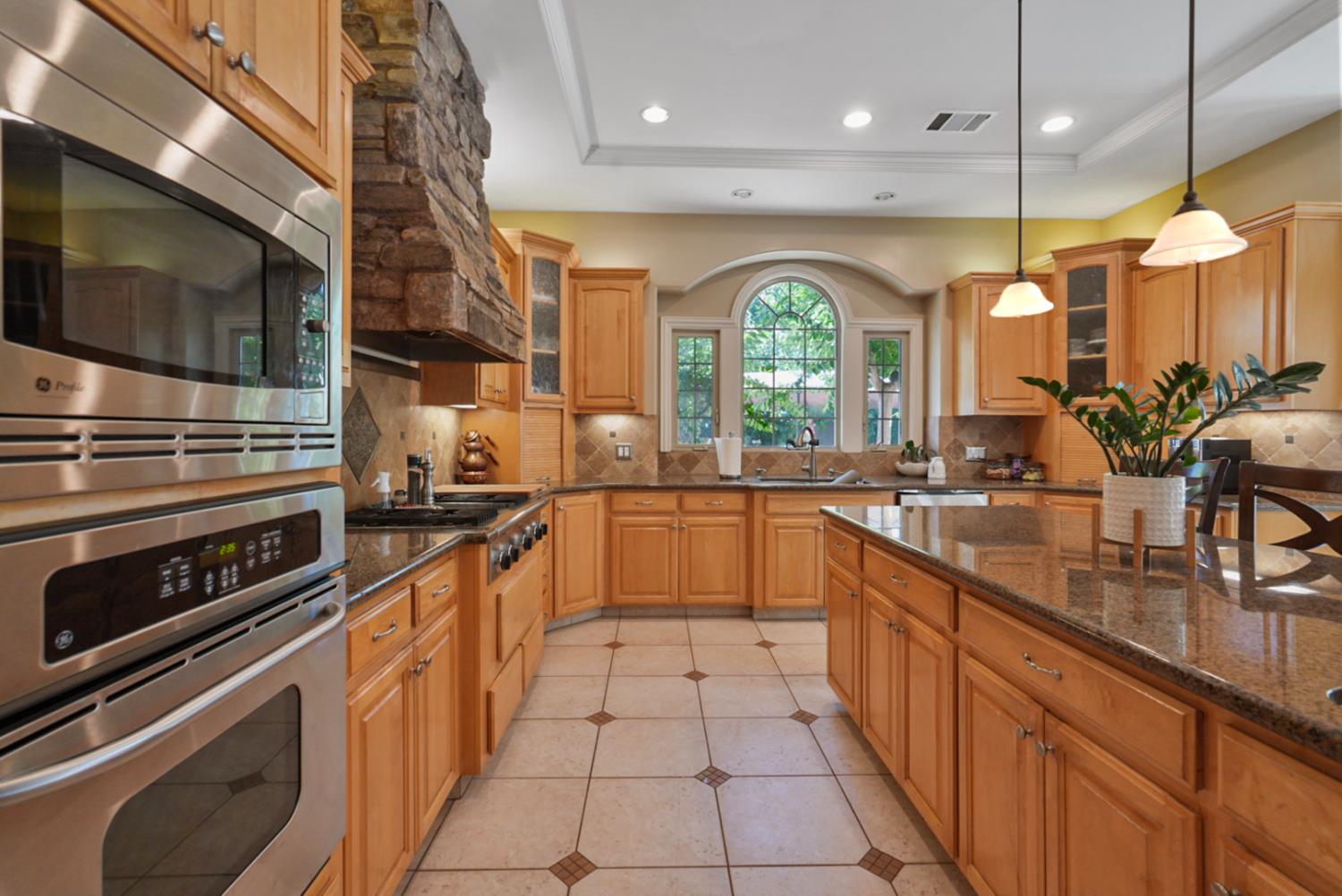 2575 Kensington Court Turlock, CA 95382 - Photo 17 of 62 a large kitchen with stainless steel appliances granite countertop a stove a sink and a microwave