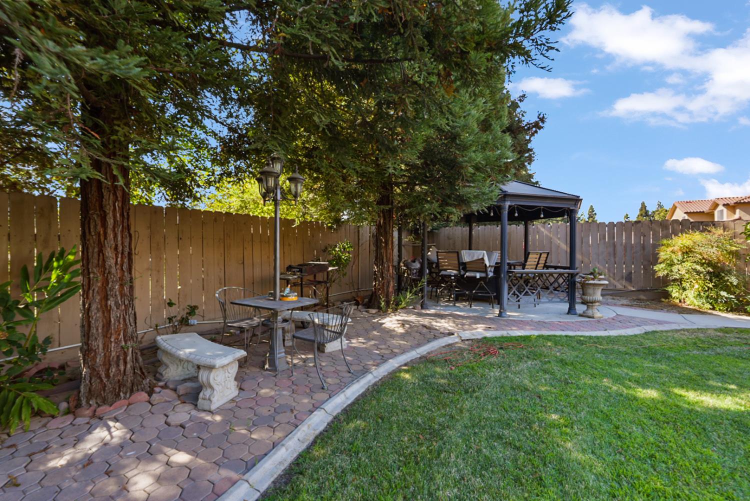2575 Kensington Court Turlock, CA 95382 - Photo 33 of 62 a view of a patio with table and chairs potted plants and a large tree