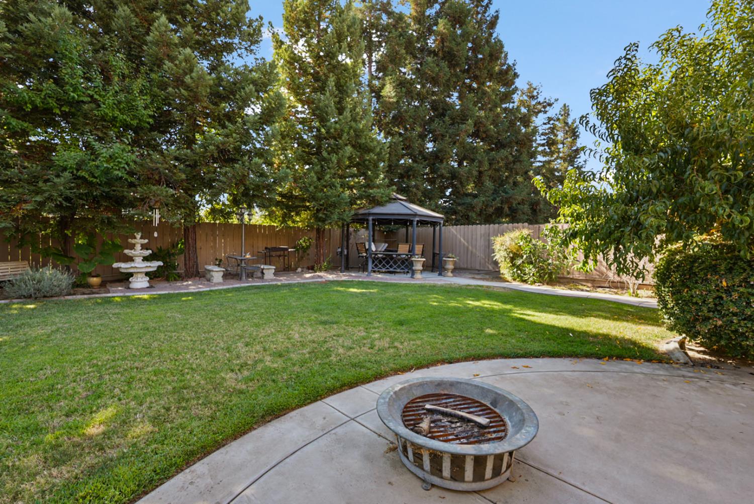 2575 Kensington Court Turlock, CA 95382 - Photo 37 of 62 a view of a fountain in front of a house with large trees
