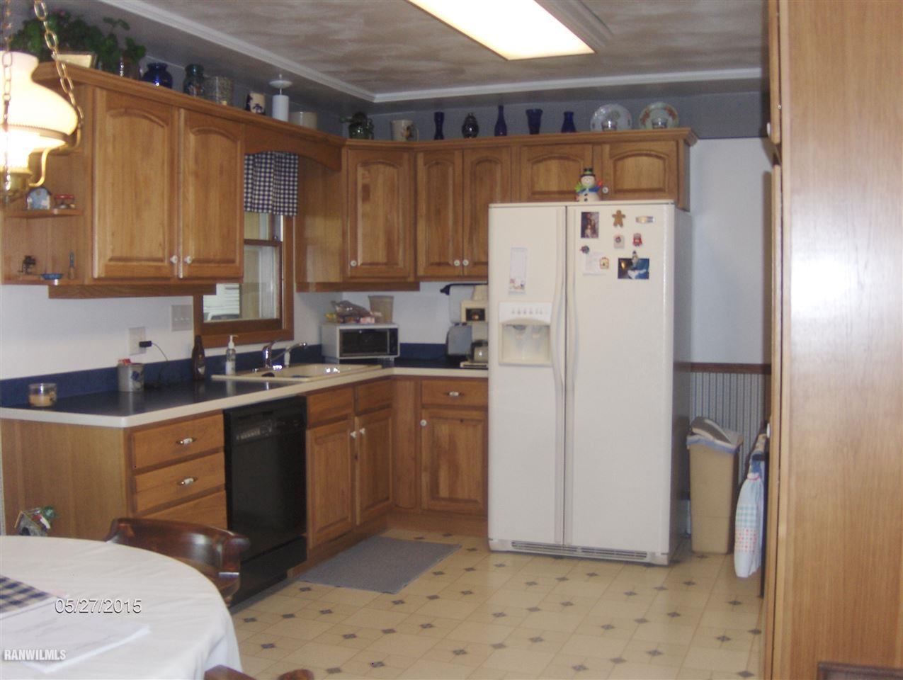 8516 East Maize Road Ridott, IL 61067 - Photo 3 of 21 a kitchen with a refrigerator and a sink