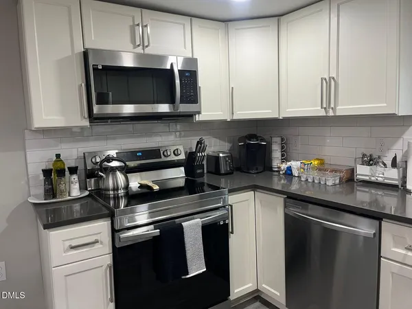 a kitchen with stainless steel appliances granite countertop a sink a stove a microwave and cabinets