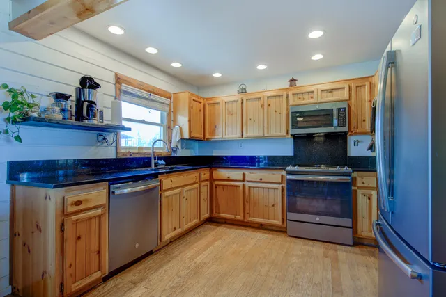 a kitchen with stainless steel appliances granite countertop a stove and a sink