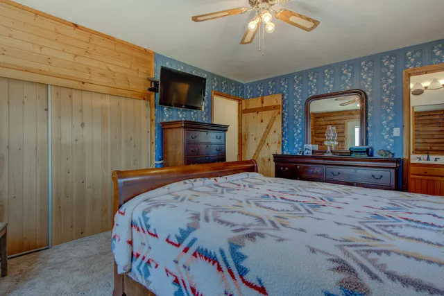 a bedroom with a bed and a flat screen tv