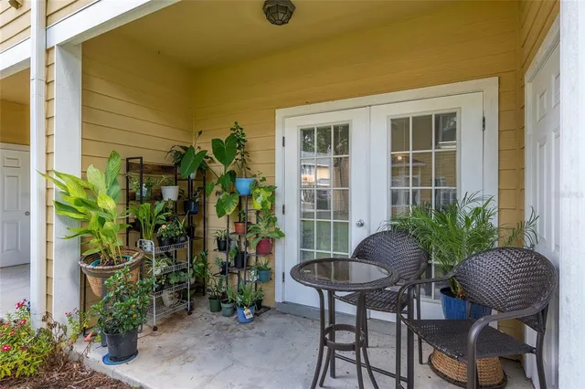 a view of a porch with chairs and potted plants