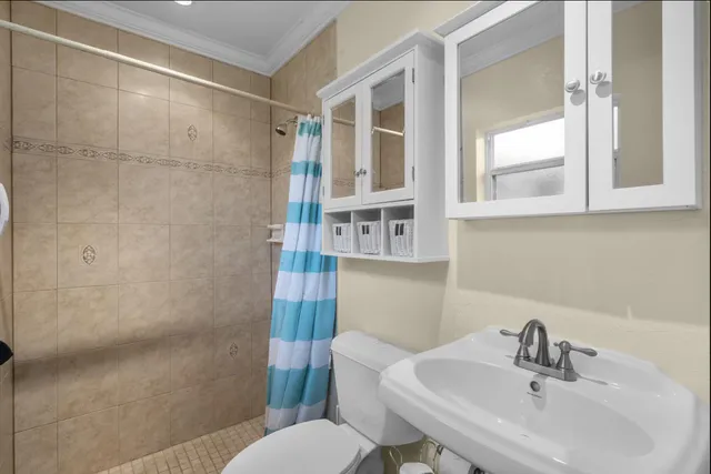 a bathroom with a sink toilet and shower