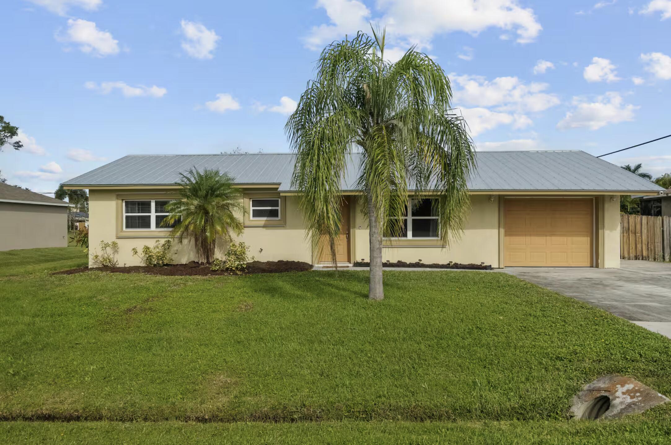 991 Southeast Walters Terrace Port St. Lucie, FL 34983 - Photo 2 of 19 a front view of a house with a garden