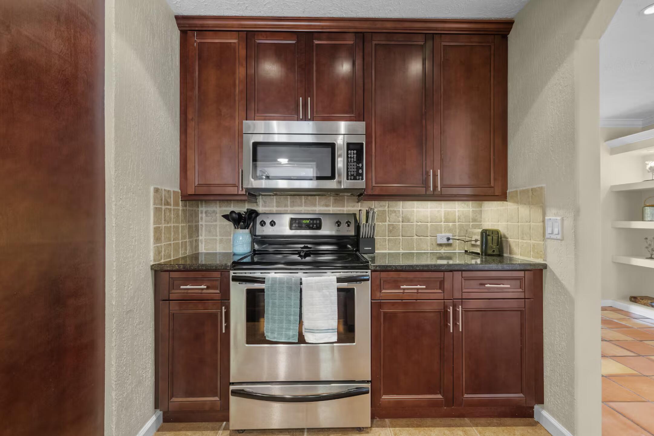 991 Southeast Walters Terrace Port St. Lucie, FL 34983 - Photo 7 of 19 a kitchen with granite countertop wood cabinets and stainless steel appliances