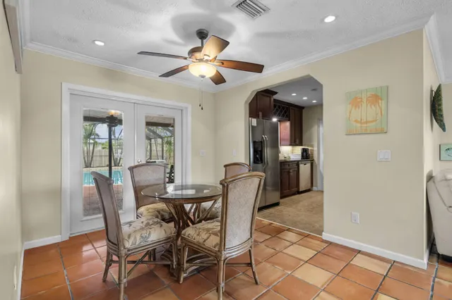 a dining room with furniture and chandelier fan